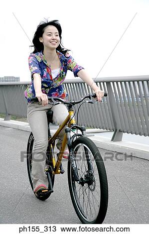 Young woman riding a bicycle View Large Photo Image Stock Image - Young woman riding a bicycle. Fotosearch