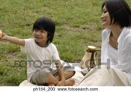 Young woman sitting with her daughter on a mat View Large Photo Image Stock Image - Young woman sitting with her daughter on a mat. Fotosearch