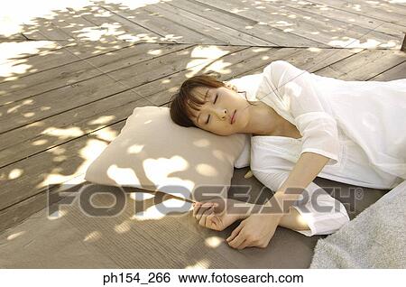 Young woman sleeping on a mat View Large Photo Image Stock Photograph - Young woman sleeping on a mat. Fotosearch
