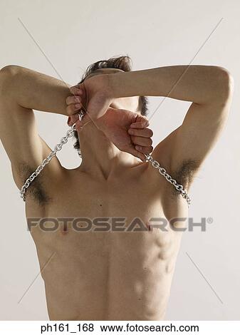 A bare-chested man pulling a metal chain View Large Photo Image Stock Photo - A bare-chested man pulling a metal chain. Fotosearch