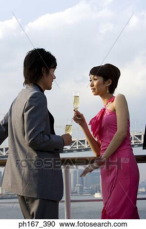 Stock Image - A couple enjoying the view onboard a cruise ship. Fotosearch