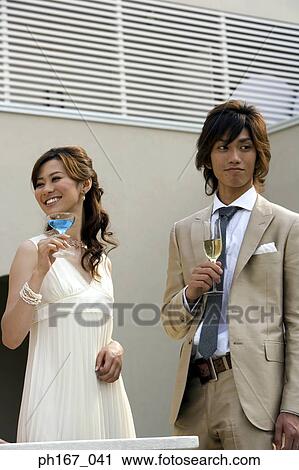 Stock Image - A couple having cocktail and champagne. Fotosearch