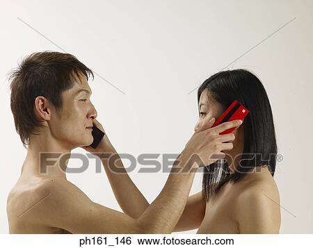 A couple holding phone to each other's ears View Large Photo Image Stock Photograph - A couple holding phone to each other's ears . Fotosearch