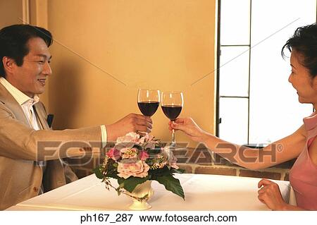 A couple making a toast in a restaurant View Large Photo Image Stock Photo - A couple making a toast in a restaurant. Fotosearch