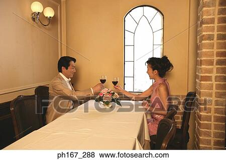 A couple making a toast in a restaurant View Large Photo Image Stock Photo - A couple making a toast in a restaurant. Fotosearch
