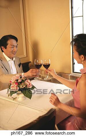 A couple making a toast in a restaurant View Large Photo Image Stock Photograph - A couple making a toast in a restaurant. Fotosearch