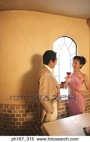 A couple relaxing by the window with wine View Large Photo Image Stock Photography - A couple relaxing by the window with wine. Fotosearch