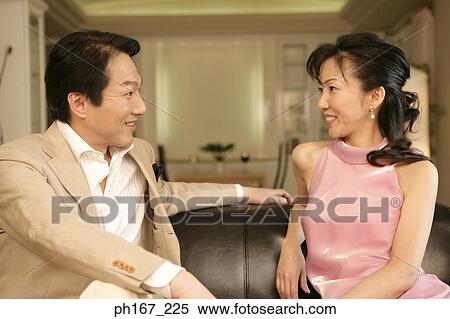 Stock Photography - A couple sitting at sofa. Fotosearch