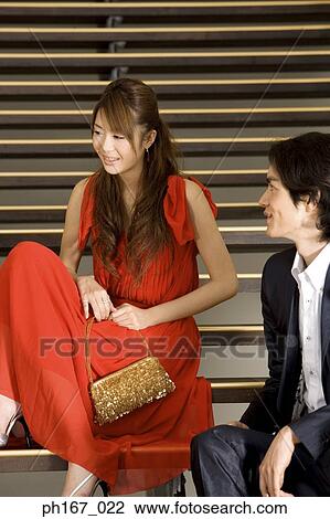 Stock Image - A couple sitting on steps. Fotosearch