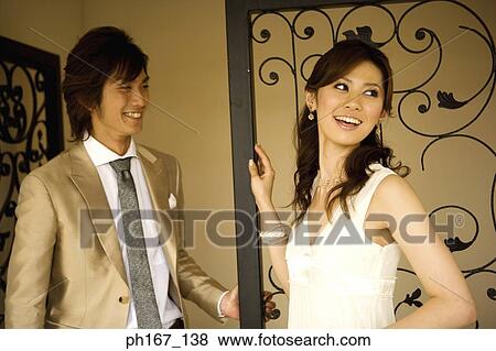 A couple standing by iron gate View Large Photo Image Stock Photo - A couple standing by iron gate. Fotosearch
