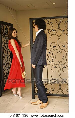 Stock Photograph - A couple standing by iron gate. Fotosearch