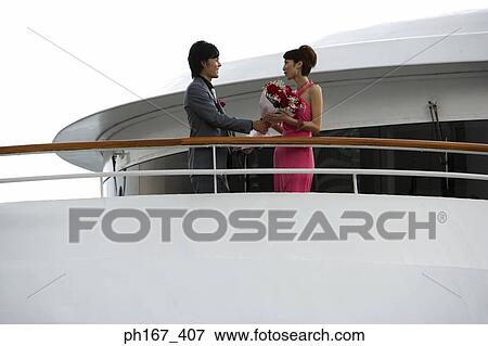 A couple standing by the railing of a cruise ship View Large Photo Image Stock Photo - A couple standing by the railing of a cruise ship. Fotosearch
