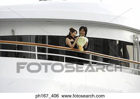 A couple standing by the railing of a cruise ship View Large Photo Image Stock Photograph - A couple standing by the railing of a cruise ship. Fotosearch