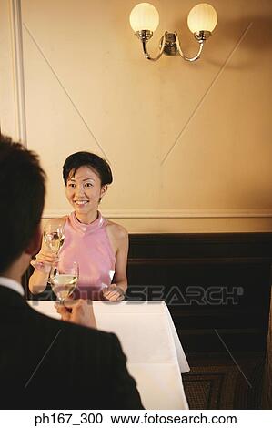 Stock Image - A couple toasting with white wine. Fotosearch