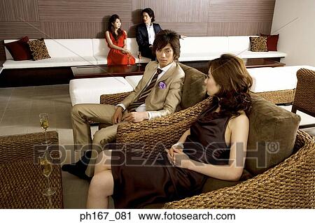 Stock Image - A couple with others, relaxing, high angle view. Fotosearch