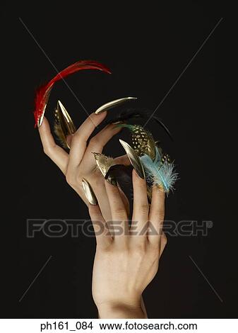 Picture - A pair of hands with feathers on finger nails. Fotosearch