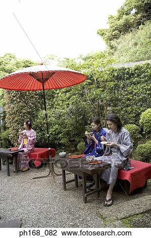 Stock Image - A small group of people enjoying a meal in the garden. Fotosearch