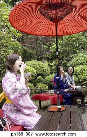 Stock Photo - A small group of people enjoying a meal in the garden. Fotosearch