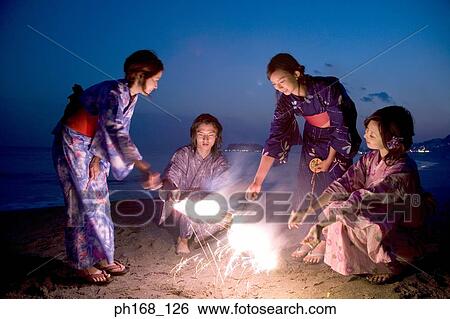 A small group of people with sparklers at the beach View Large Photo Image Stock Photograph - A small group of people with sparklers at the beach. Fotosearch