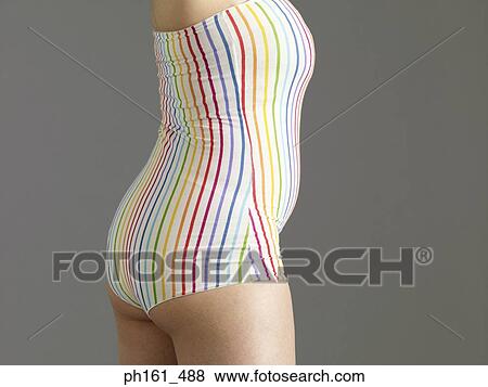 Stock Photo - A woman in striped swimsuit, standing. Fotosearch