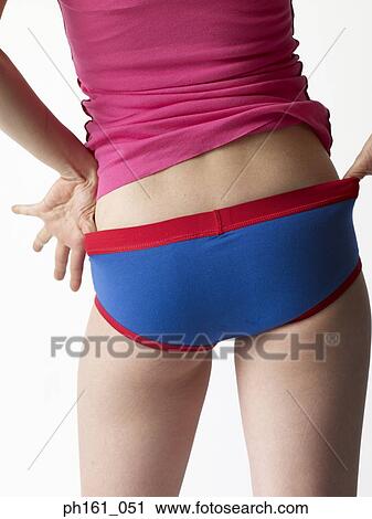 Stock Image - A young woman in pink T shirt, briefs, back view, close-up. Fotosearch