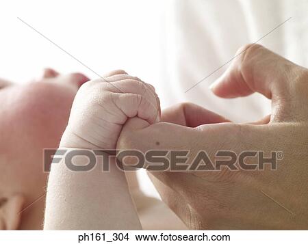 Picture - Baby bonding with an adult. Fotosearch