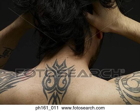 Stock Image - Bare chested man pulling his hair, back view. Fotosearch