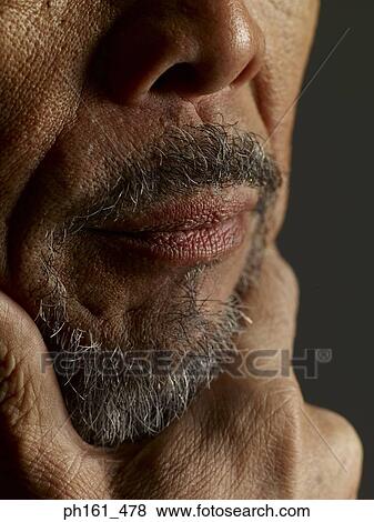 Stock Photo - Close-up of a mature man holding his chin. Fotosearch