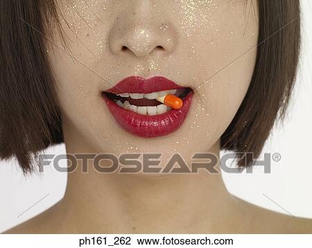 Close-up of a woman with red lips, biting a pill View Large Photo Image Stock Image - Close-up of a woman with red lips, biting a pill. Fotosearch