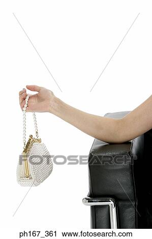Stock Image - Close-up of a woman's hand holding a handbag. Fotosearch