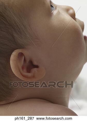 Close-up of baby looking up, side view View Large Photo Image Stock Photo - Close-up of baby looking up, side view. Fotosearch