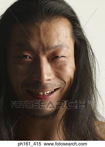 Stock Photography - Close-up of young man with long hair, smiling. Fotosearch