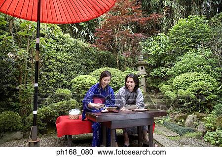 Stock Image - Couple enjoying a meal in the garden. Fotosearch