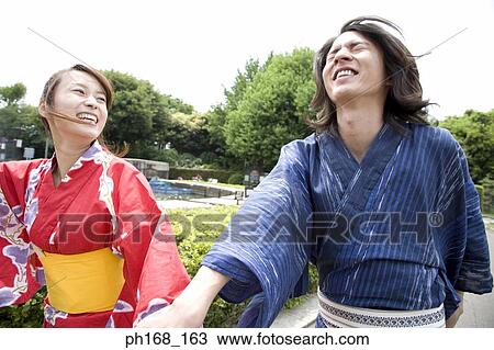 Couple in traditional Japanese clothing walking in the park, laughing View Large Photo Image Stock Image - Couple in traditional Japanese clothing walking in the park, laughing. Fotosearch