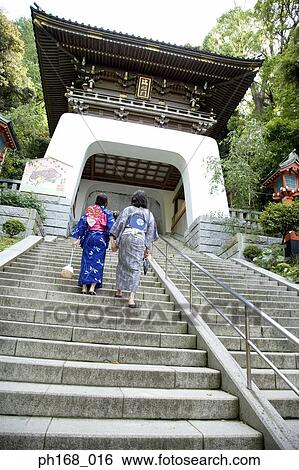 Stock Photograph - Couple in traditional Japanese clothing climbing up the steps, rear view. Fotosearch