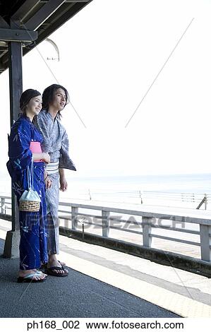 Stock Image - Couple in traditional Japanese clothing, holding hands. Fotosearch