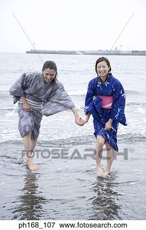 Stock Photo - Couple in traditional Japanese clothing, playing by the sea. Fotosearch