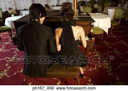 Couple playing piano together, rear view View Large Photo Image Stock Photo - Couple playing piano together, rear view. Fotosearch