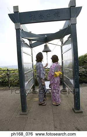 Couple ringing a bell, rear view View Large Photo Image Stock Photograph - Couple ringing a bell, rear view. Fotosearch