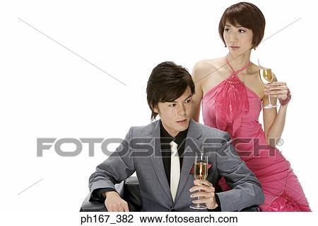 Couple sitting on a sofa with champagne View Large Photo Image Stock Image - Couple sitting on a sofa with champagne. Fotosearch