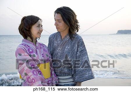 Couple standing by the beach View Large Photo Image Stock Photography - Couple standing by the beach. Fotosearch