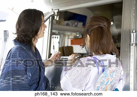 Stock Image - Couple standing by van. Fotosearch