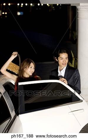 Couple standing next to limousine with door open View Large Photo Image Stock Photo - Couple standing next to limousine with door open. Fotosearch