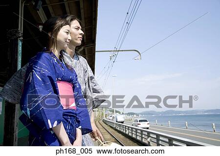 Stock Photography - Couple waiting for train in traditional Japanese clothing. Fotosearch
