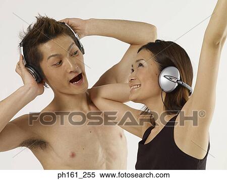 Stock Photography - Couple with headphones, dancing. Fotosearch