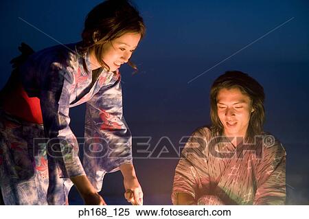 Stock Photography - Couple with sparklers at the beach. Fotosearch