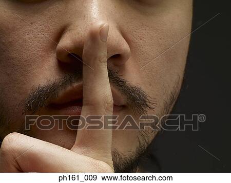 Stock Photo - Man holding finger to his lips. Fotosearch