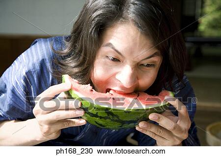 Man in traditional Japanese clothing biting into water melon, close-up View Large Photo Image Stock Image - Man in traditional Japanese clothing biting into water melon, close-up. Fotosearch