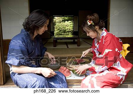 Man looking at woman in kimono cutting up a water melon View Large Photo Image Stock Photograph - Man looking at woman in kimono cutting up a water melon. Fotosearch