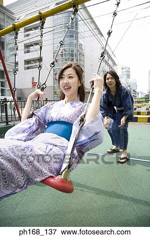 Man pushing a woman on a swing View Large Photo Image Stock Photo - Man pushing a woman on a swing. Fotosearch